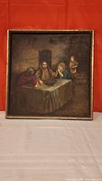 Full view of framed oil painting showing Jesus and three others at table.