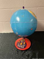 Front view of globe showing the North Pacific Ocean and red base with audio controls.
