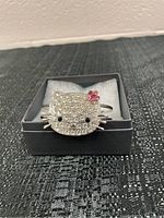 Top view of Hello Kitty rhinestone bracelet in display box on black textured surface.