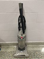 Full view of Hoover WindTunnel upright vacuum cleaner showing handle, power cord, and dust canister.