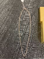 Full view of the 925 silver necklace laid flat showing thin chain and clasp.