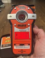 Front view of BLACK+DECKER Bulls Eye BDL190S auto-leveling laser device showing laser aperture, brand name, and caution labels.