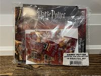 Photo of sealed package containing the Harry Potter Official Pin Collection, showing 18 pins included in the set, with branded packaging.