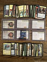 Top view of most cards laid out on wood surface showing multiple stacks and loose cards with visible holograms and character cards.