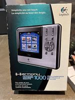 Box packaging showing Logitech Harmony Advanced 1000 remote control with product brand and key features in English and French.