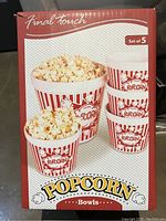 Front of original box showing set of 5 red and white striped ceramic popcorn bowls filled with popcorn.