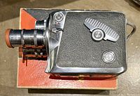 Top view of the vintage Keystone Olympic 8MM Movie Camera showing triple lens turret and winding lever on black textured body with chrome accents.