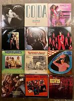 Photo showing 12 vintage vinyl record covers including John Lennon, Led Zeppelin, Donna Summer, Rod Stewart, Ventures, Village Stompers, James Last Band, Elvis, Beach Boys, Monkees.