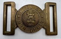 Front view of the Victorian brass waist belt buckle showing central lion above crown and surrounding motto.