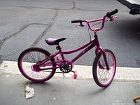 Full side view of a purple BMX style kids bike showing frame, wheels, seat and handlebars