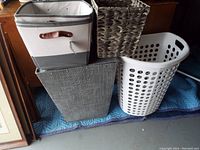 Four assorted hampers and small containers arranged together on a padded blue mat, showing condition and variety