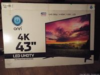 Box of ONN 43 inch 4K UHD LED TV showing brand, model, and specifications