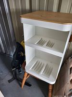 White Tempo Move storage case/stand with wooden top and base showing two shelves with vertical slots for organizing the device