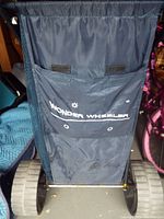 Front view of blue Wonder Wheeler cart fabric bag with logo and pockets
