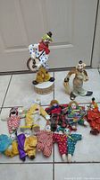 Full view of clown collection showing the Capodimonte clown statue, other clown statue, and multiple small clown dolls in various colorful outfits.