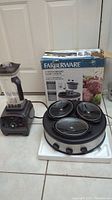 Mengk blender and Farberware slow cooker side by side with slow cooker box in background