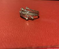 Ring front and top view showing shooting stars design with diamonds on a red surface.