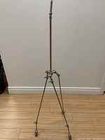 Full view of the industrial light fixture showing the tripod base and central vertical rod.