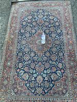 Full view of rug laid out on ground with water bottle at center