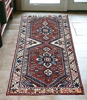Full view of rug on tiled floor showing overall pattern and colors.