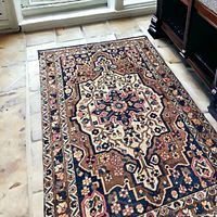 Rug laid on stone floor beside furniture, showing overall pattern and wear
