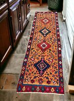 Full-view of yellow-field shiraz wool runner laid on floor between cabinets