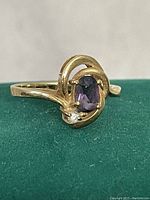 Front view showing oval amethyst stone and small diamond in polished 10Kt gold setting.