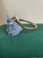 Profile view showing fan-shaped topaz set in gold prongs