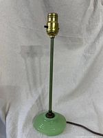 Full view of vintage table lamp with jadeite green glass base and green metal stem.