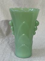 Full front view of pale green opaque jadeite vase with scalloped rim and bead detail sides