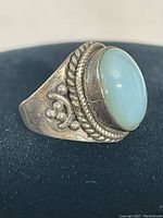 Close-up angled photo of the vintage sterling silver ring highlighting the jade stone and ornate silver details on the side.