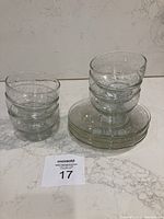 Six glass dessert bowls and five plates stacked and grouped, showing set quantity and style.