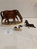 Set of three horse figurines: large mare and foal, small black and white lying foal and a small paint pony.