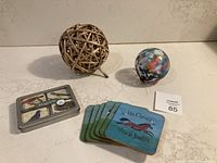 Overview of all four items included in the lot: wicker decor ball, blown glass ornament, box of bird magnets, and animal-themed coasters.