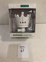 Photo of night light in original packaging showing white ceramic crown shape and brand on box