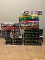 Full view of all manga volumes stacked on table showing variety of titles and volume numbers