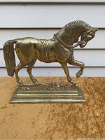 Front view of the brass horse doorstop "Copenhagen," showing prancing pose and detailed mane and tail.