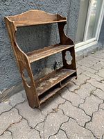 Full view of antique pine hanging shelf showing three shelves, two cubbies at the bottom, and decorative quatrefoil cutouts on the sides with aged wood finish.