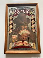 Full front view of the vintage Budweiser poker mirror clock showing cowboy holding poker cards and Budweiser branding.