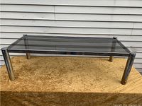 Front view showing rectangular smoked glass top and tubular chrome legs