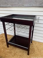 Front view showing mirror top, metal bottles wine rack for 10 bottles, and lower shelf