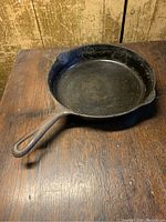 Cast iron frying pan showing side view with handle and one pouring spout