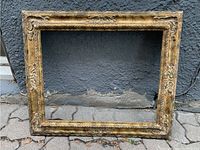 Full view of the rectangular gilt picture frame with patinated gilding and decorative floral details.