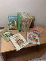 Photo showing a group of children’s books including The Mystery at the Moss-Covered Mansion, The Big Honey Hunt, The Cat in the Hat, Little Mommy, and Bingsle among others arranged on a wooden surface.