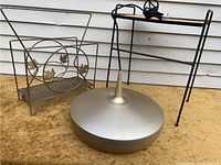 Three-piece lot showing side table, magazine rack, and pendant light on carpet with siding background