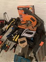 Photo showing a selection of hand and power tools, including circular saw, staple gun, and tile cutter saw