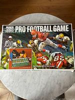 Box cover showing vintage Parker Pro Football Game art with football players and game scene, includes inset of two people playing the game.