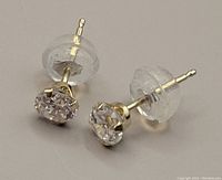 Front view close-up of both earrings showing clear stones and gold prong settings