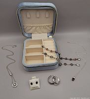All sterling silver jewelry pieces displayed with velvet travel box, showing necklaces, bracelets, earrings.