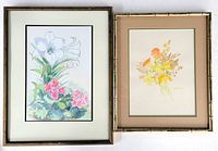 Photo shows both framed floral watercolour paintings side-by-side on a white surface. Larger painting (Diane Dobson) on left with white lilies and pink flowers. Smaller painting (Arrowsmith) on right with warm-toned flowers. Both framed, matted and under glass.
